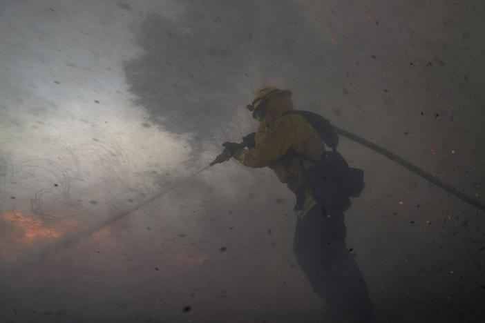 A firefighter battles the Silverado Fire Monday,in Irvine, Calif. The wildfire forced evacuation orders for 60,000 people in Southern California.