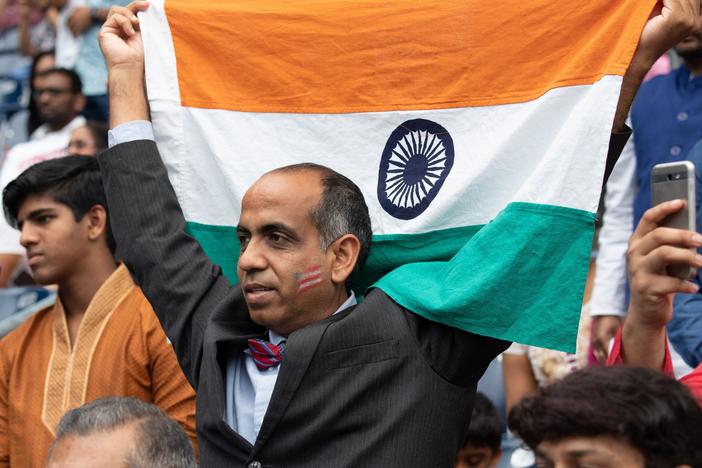 A man holds up an Indian flag during a rally with President Trump and Prime Minister Modi in Houston in September 2019. Trump and Modi have spoken of their friendship, but most Indian Americans say U.S.-India ties are low on their political priorities.