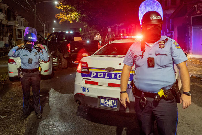 Police officers stand guard in Philadelphia following protests over the police shooting death of Walter Wallace on Tuesday.