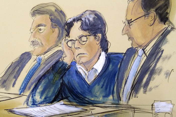 Keith Raniere was sentenced on Tuesday to 120 years in prison for his role as ringleader of the NXIVM cult, where he sexually abused several young women. In this June 2019 courtroom artist's sketch, Raniere, center, sits with his attorneys during closing arguments at federal court in Brooklyn, N.Y.