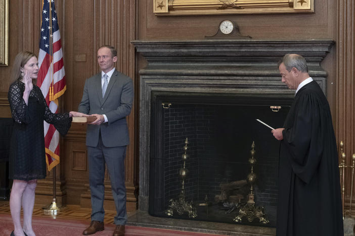 Chief Justice John Roberts Jr. administers the judicial oath to Judge Amy Coney Barrett at the Supreme Court on Tuesday. Barrett's husband, Jesse, holds the Bible.