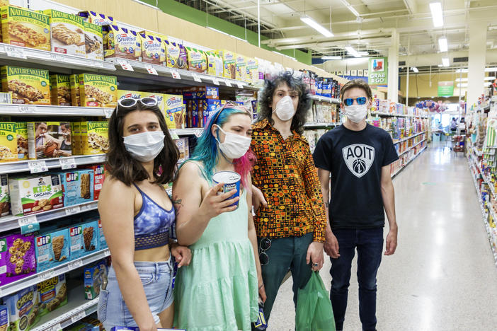 Increasingly, many people in the U.S., like these teens in a Miami grocery story in August, now routinely wear face masks in public to help stop COVID-19's spread. But social distancing and other public health measures have been slower to catch on, especially among young adults, a national survey finds.