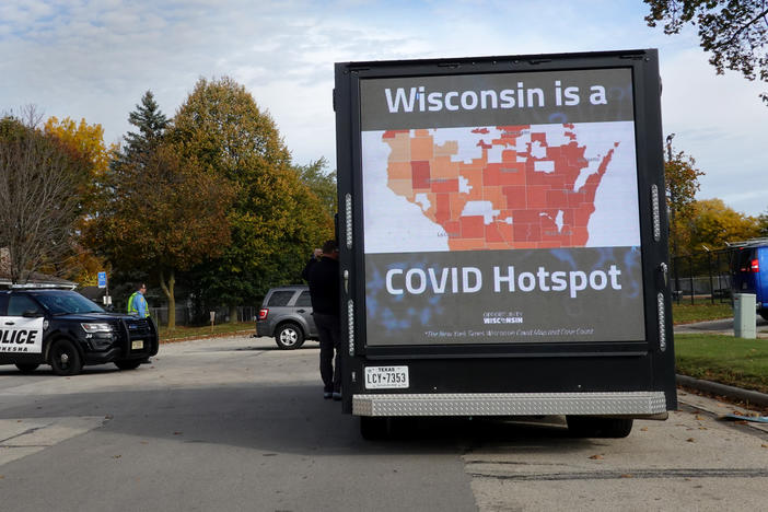 Police stand guard outside of a rally with Vice President Pence  on Oct. 13 in Waukesha, Wis. The state is experiencing a surge of COVID-19 cases, threatening to overwhelm rural hospitals.