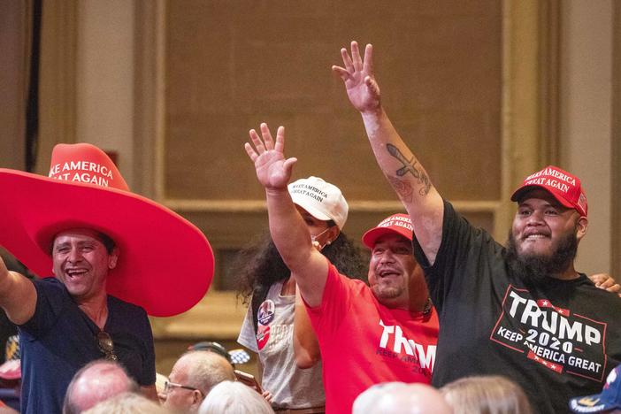 Supporters of President Trump wave during a Latinos for Trump roundtable last month at the Arizona Grand Resort in Phoenix.