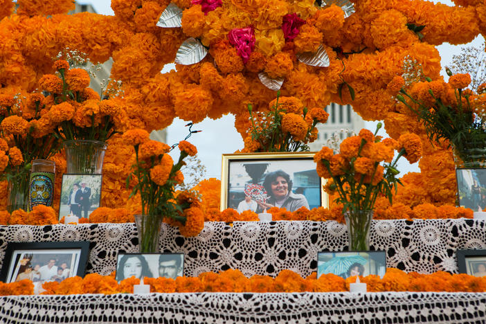 <em>Altarista </em>Ofelia Esparza says it's been "a nightmare year" of loss for her family. Above, framed photographs of loved ones lost at her community altar in Grand Park.