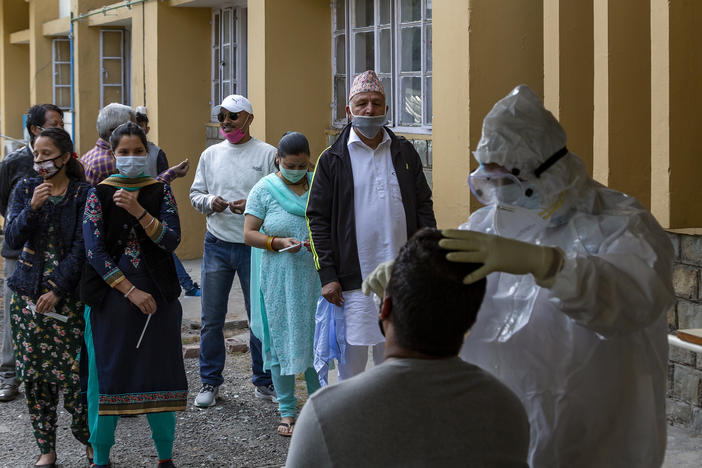 A health officer in a protective suit collects a swab sample to be tested for the coronavirus on Thursday in Dharmsala, India. India's confirmed coronavirus caseload surpassed 8 million on Thursday.