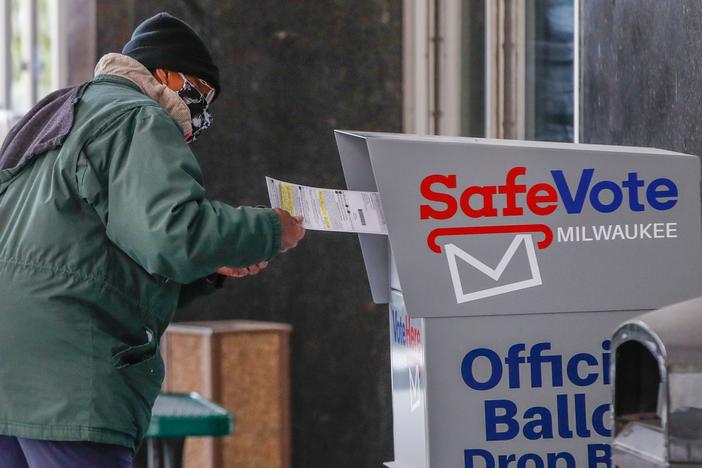 A woman casts her ballot on the first day of in-person early voting for the 2020 elections in Milwaukee on Oct. 20. With just days left until Election Day, both President Trump and Democratic presidential nominee Joe Biden will head to the Badger State for dueling campaign events on Friday.