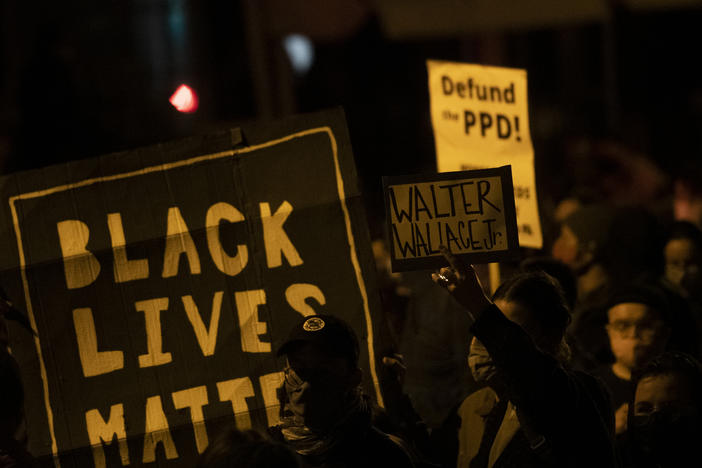 Demonstrators hold placards reading "BLACK LIVES MATTER," "Walter Wallace JR." and DEFUND PPD" as they gather in protest near the location where Wallace, a 27-year-old Black man, was killed by two police officers in Philadelphia. Police officers said he was armed with a knife.