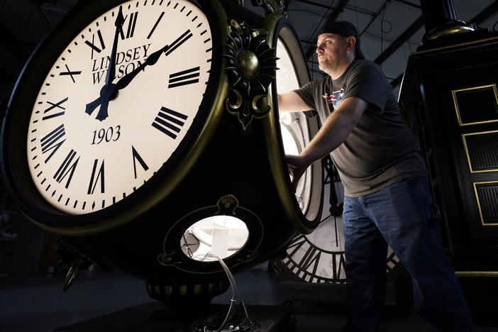 Dan LaMoore works on a Seth Thomas Post Clock at Electric Time Company on Oct. 23, in Medfield, Mass. Daylight saving time ends at 2 a.m. local time Sunday.