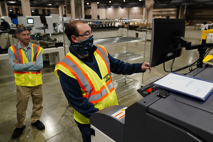 John Hansberry with the Philadelphia City Commissioners Office runs a sorting machine at the city's mail-in ballot sorting and counting center on Oct. 26.