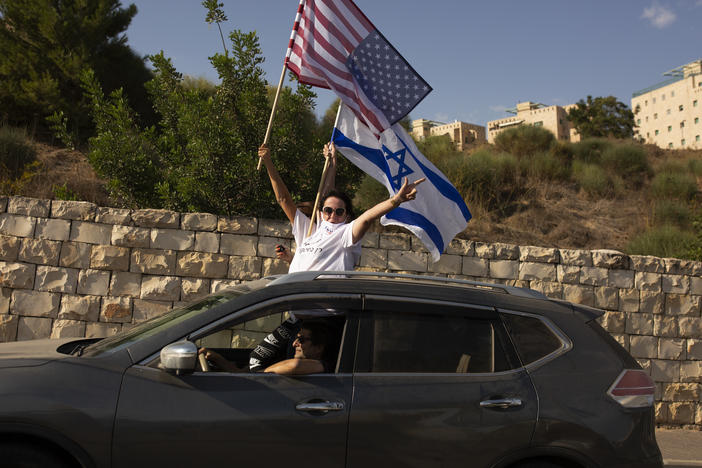 Supporters of President Trump wave U.S. and Israeli flags from a car last week headed for a rally outside the U.S. Embassy in Jerusalem.