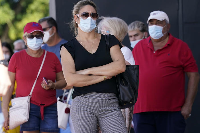 People stand in line for early voting at the John F. Kennedy Library on Oct. 27 in Hialeah, Fla.