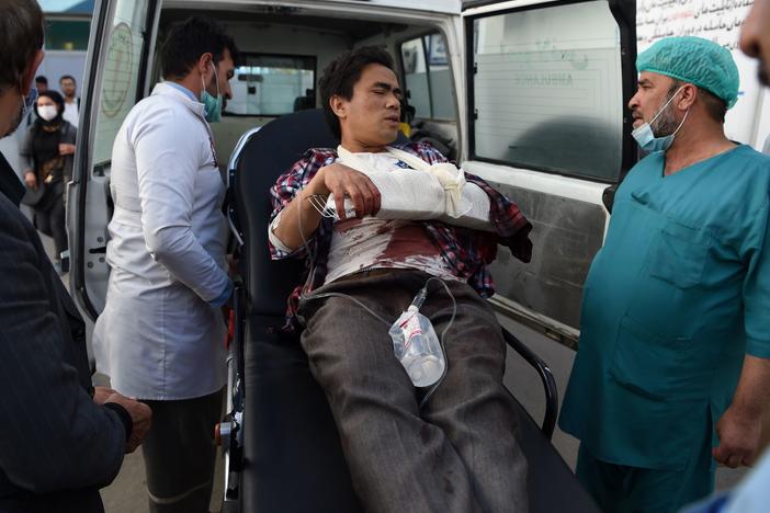 A man, wounded after gunmen stormed Kabul University, arrives in an ambulance at Isteqlal Hospital on Monday. At least 19 people died in the attack on Afghanistan's largest university.