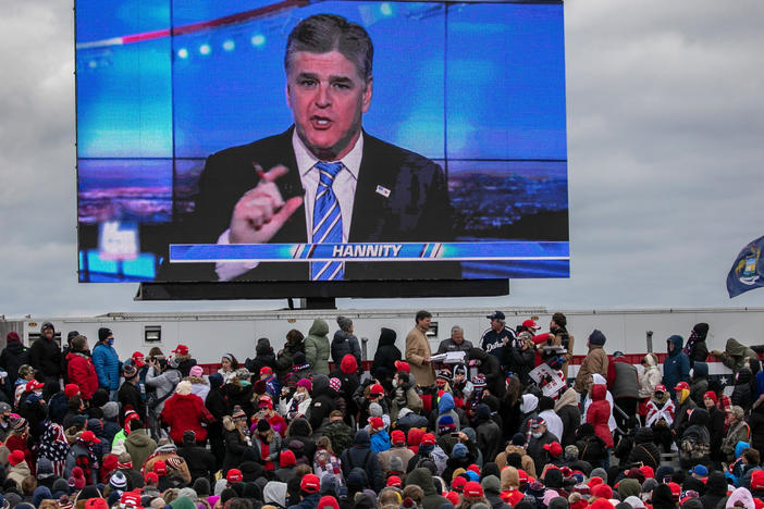 Supporters of President Trump watch a video featuring Fox News host Sean Hannity ahead of Trump's arrival for a campaign rally Friday in Waterford Township, Mich.
