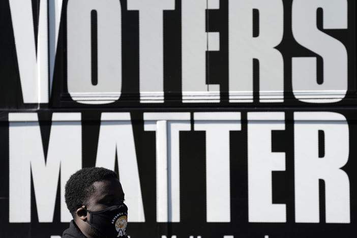 A man wearing a mask at an Election Day rally at the Graham Civic Center polling site in Graham, N.C.