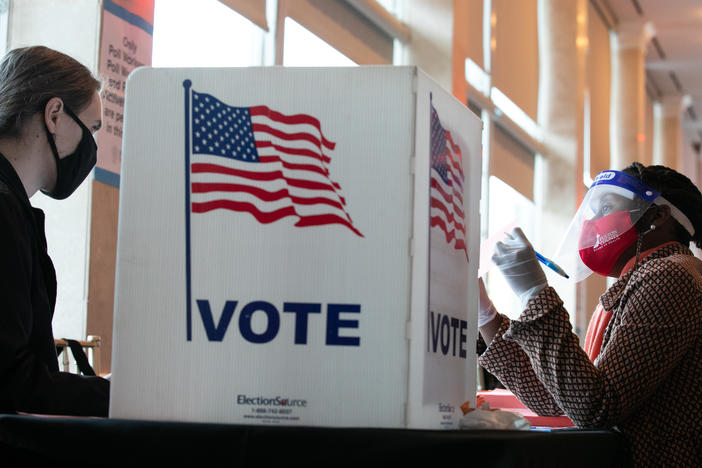 A poll worker helps K. Maki (left) fill out a provisional ballot at Park Tavern polling station on Tuesday in Atlanta, Ga. After a record-breaking early voting turnout, Americans head to the polls on the last day to cast their vote.