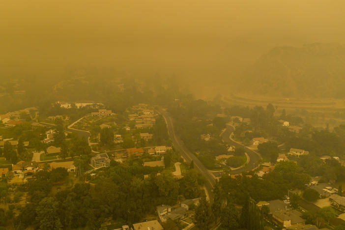 Climate change has been a key factor in increasing the risk and extent of wildfires and other catastrophic weather events. Here, an aerial view shows neighborhoods in Monrovia, Calif., shrouded in smoke from the Bobcat Fire in September.