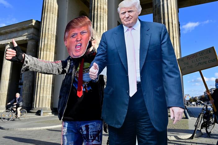 A supporter of President Trump poses with a cardboard-cutout likeness Wednesday in front of the Brandenburg Gate in Berlin.