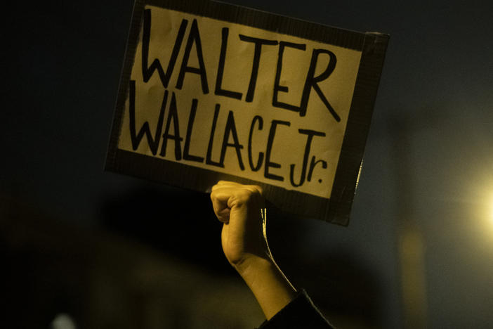 A demonstrator holds a placard with Walter Wallace Jr.'s name on it during a protest near the location where he was killed by two police officers in Philadelphia.