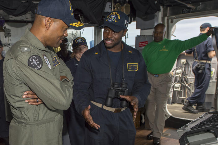 Rear Adm. Alvin Holsey (left) speaks with Ensign Dimitri Foster in the pilothouse aboard guided-missile cruiser USS Lake Champlain in 2018.