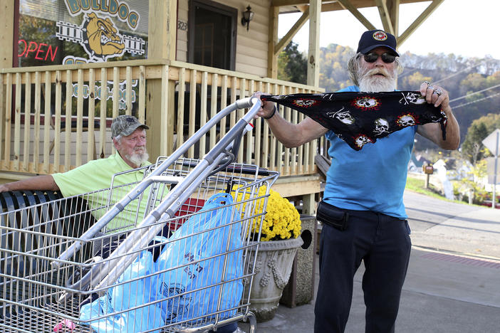 A man displays his face covering for protection against the coronavirus in West Union, W.Va., last month. Small communities from the Dakotas to Kansas to West Virginia have recently seen coronavirus cases rising again.