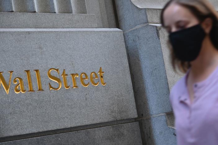 A woman walks by the New York Stock Exchange on Oct. 5. Stock markets are rallying at the prospect that this week's elections will result in a divided government.