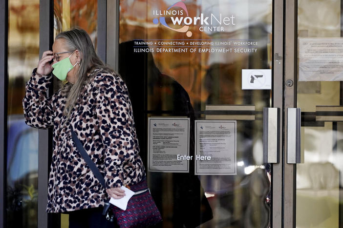 A woman reacts as she leaves the Illinois Department of Employment Security WorkNet center in Arlington Heights, Ill., on Thursday. The state has reported a spike of nearly 10,000 new coronavirus cases. It also reports biggest spike in unemployment claims of all states due to the pandemic.