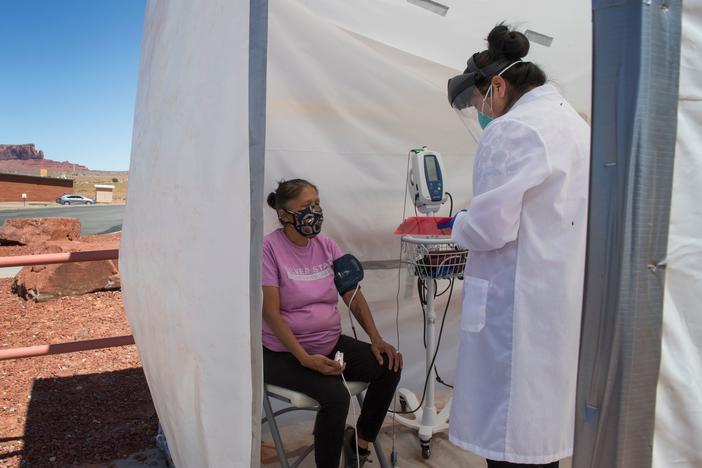 A nurse checks vitals for a Navajo woman, who came to a coronavirus testing center in Arizona, complaining of virus symptoms.