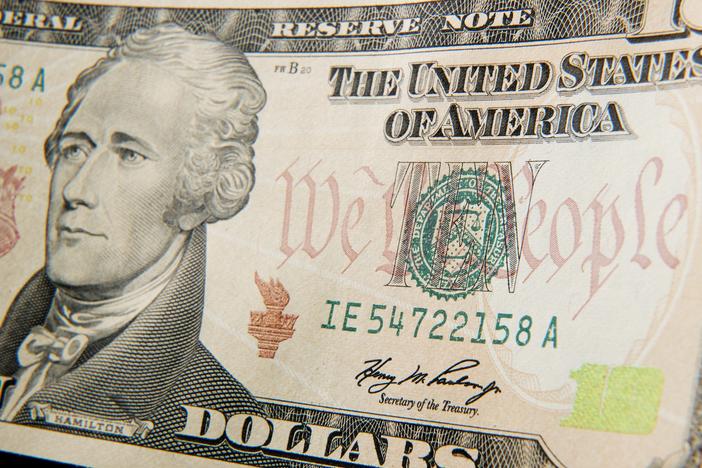 A close-up of the front of the US 10-dollar bill bearing the portrait of Alexander Hamilton, America's first Treasury Secretary.