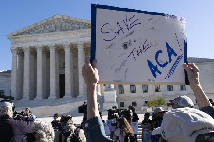 A demonstrator holds a sign in front of the U.S. Supreme Court, which heard arguments over the Affordable Care Act Tuesday.