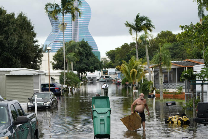 Residents clear debris from a flooded street in the Driftwood Acres Mobile Home Park, in the aftermath of Tropical Storm Eta, on Tuesday in Davie, Fla.