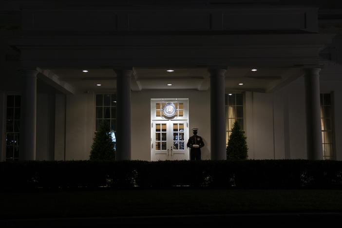 A Marine stands outside the entrance to the West Wing of the White House on Tuesday, signifying that President Trump is in the Oval Office.