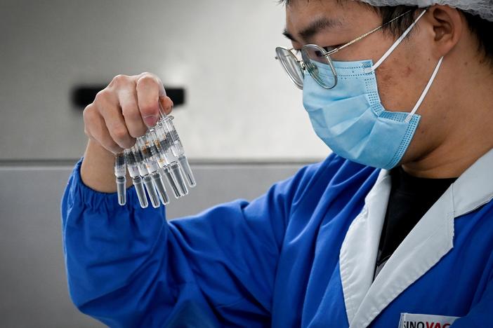 A staff member checks vaccines at a Beijing factory built by Sinovac to produce a COVID-19 coronavirus vaccine. Sinovac is one of 11 Chinese companies approved to carry out clinical trials of potential vaccines.
