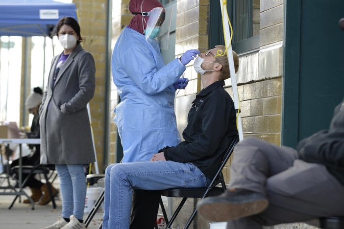A medical staff member performs a COVID-19 test outside the Family Healthcare building in downtown Fargo, North Dakota, on Oct. 15. North Dakota is experiencing an influx in COVID-19 cases and on Nov. 6, the state reported a record high of 1,765 daily new cases.