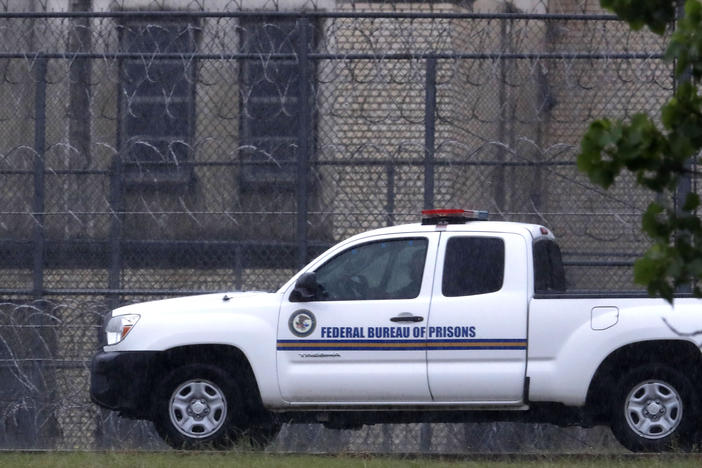 A Federal Bureau of Prisons truck drives past barbed wire fences at the Federal Medical Center prison in Fort Worth, Texas in May 2020.