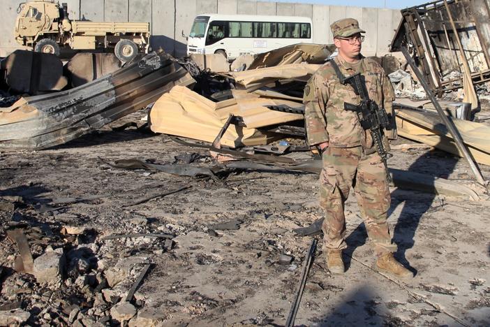 A U.S. soldier stands at a spot struck by Iranian missiles in January at Ain al-Asad air base in Iraq's Anbar province. The attack was in retaliation for the U.S. drone strike that killed Iranian Gen. Qassem Soleimani. The U.S. is drawing down 2,500 troops in Iraq and Afghanistan.