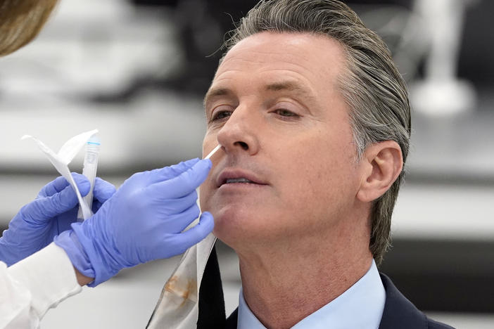 California Gov. Gavin Newsom, pictured receiving a coronavirus test on Oct. 30, apologized to residents on Monday for attending a birthday party with too many guests. "I need to preach and practice, not just preach," he said.
