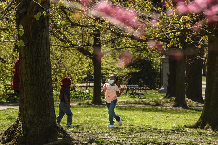A child wears a protective mask while playing in April in Prospect Park in the Brooklyn borough of New York City.