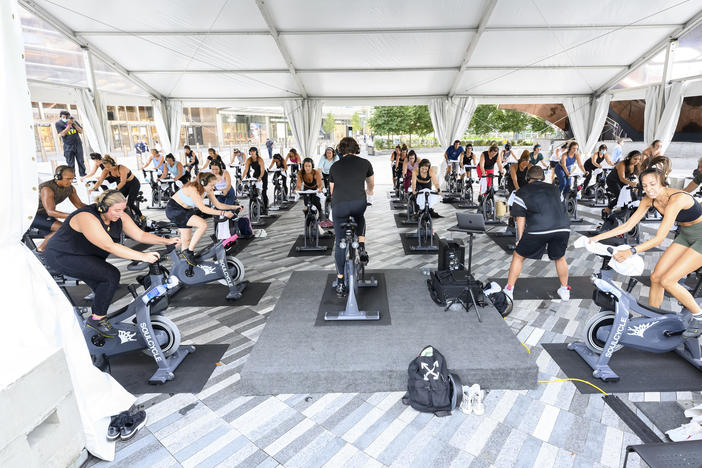 People attend a SoulCycle class under an outdoor tent in September in New York City.