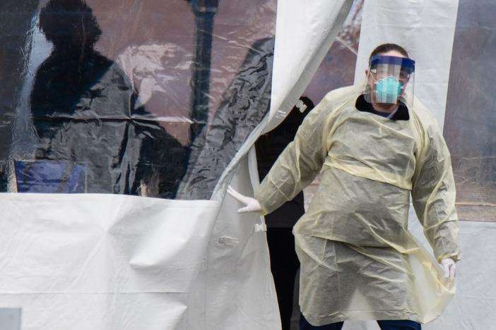 A health professional walks out of a drive-through coronavirus testing site at the University of Dayton in Ohio earlier this year. Ohio will go on a statewide curfew Thursday for at least three weeks.