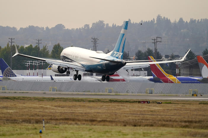 A Boeing 737 Max jet, piloted by Federal Aviation Administration chief Steve Dickson, flies past parked Boeing jets as it prepares to land at Boeing Field following a test flight in September.