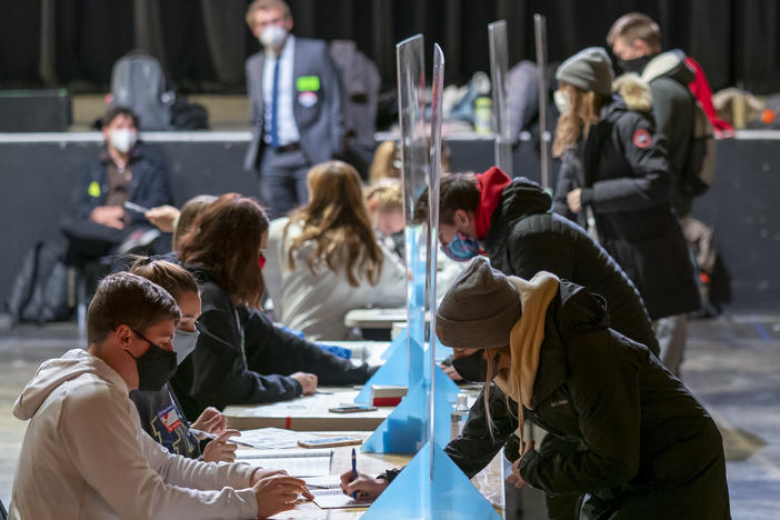 Poll workers check voters' identifications on Election Day at the Orpheum Theater in Madison, Wis. The Trump campaign has announced it is filing for a recount in two Wisconsin counties.
