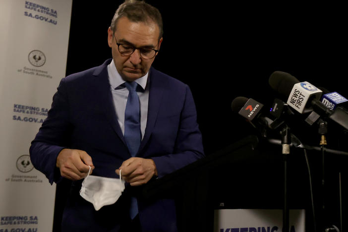 South Australian Premier Steven Marshall takes his mask off as he announces a six-day lockdown for South Australia that takes effect midnight Thursday local time.