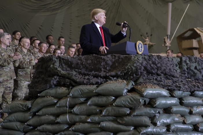 President Trump speaks to U.S. troops at Bagram Airfield, Afghanistan, on Thanksgiving Day 2019. The Trump administration says it's cutting U.S. forces from 4,500 to 2,500 troops in Afghanistan, one of several abrupt military moves announced recently.