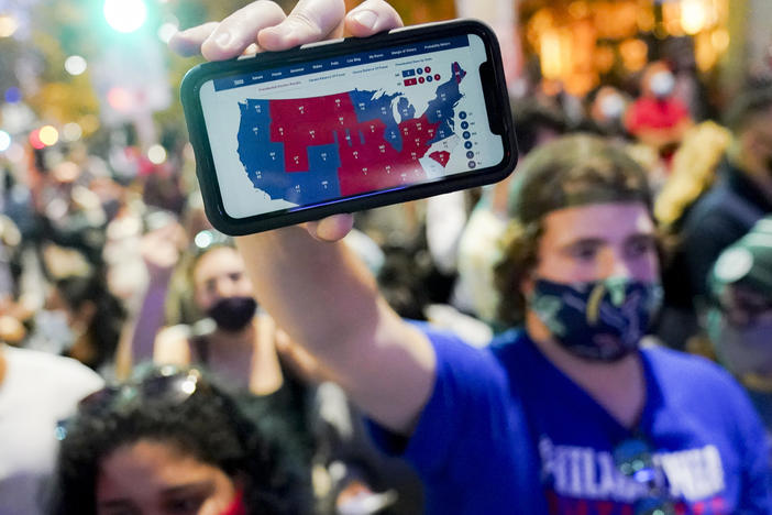 A Joe Biden supporter holds up a phone displaying the Electoral College map in Philadelphia on Nov. 7.