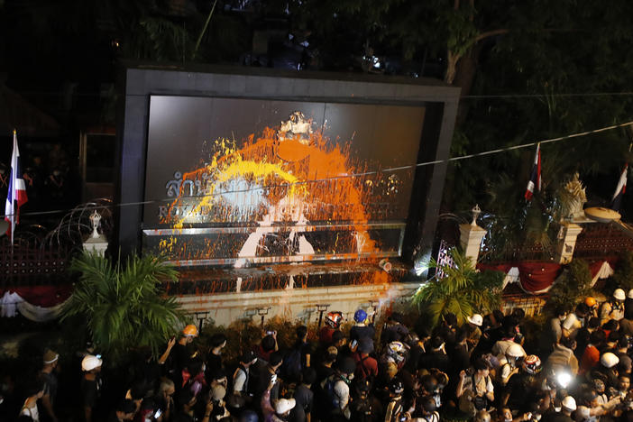 Pro-democracy protesters splash colored paint on the police headquarters sign in Bangkok, Thailand, on Wednesday.