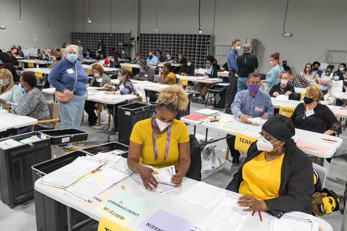 Gwinnett County election workers handle ballots Monday in Lawrenceville, Ga., as part of the state's recount for the 2020 presidential election.