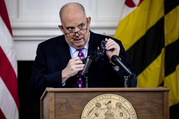 Maryland Governor Larry Hogan takes his mask off as he arrives for a press conference to address COVID-19 concerns in Annapolis, the state capital, on Tuesday.