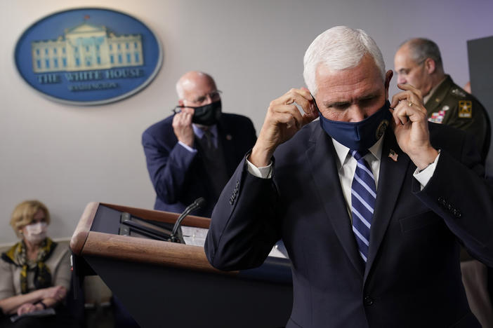 Vice President Pence adjusts his face mask during a news conference with the coronavirus task force at the White House on Thursday.