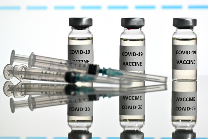 An illustration picture shows vials with COVID-19 vaccine stickers attached and syringes with the logo of U.S. biotechnology company Moderna on November 17.